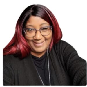 Smiling woman with glasses and red hair.